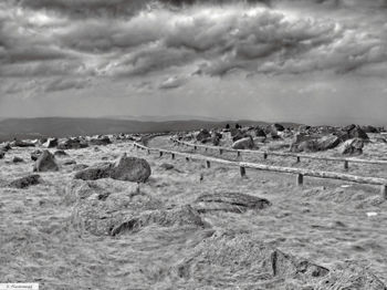 Scenic view of field against storm clouds