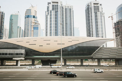 Cars on road by buildings in city