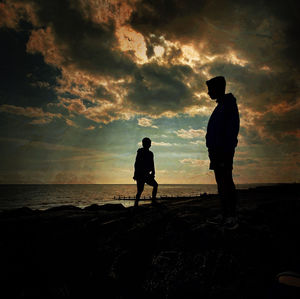 Silhouette woman walking at beach against sky during sunset