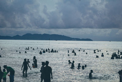 People at beach against sky