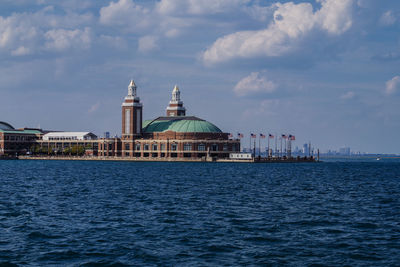 Navy pier by lake against cloudy sky