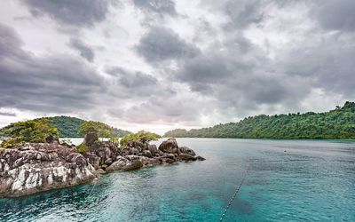Rock formations by sea against sky