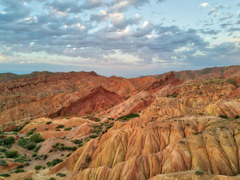 Scenic view of desert against cloudy sky