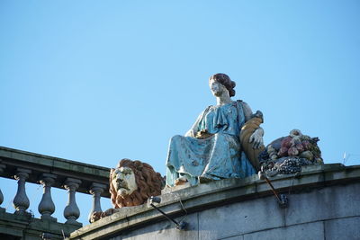 Low angle view of statue against clear blue sky