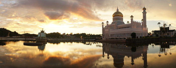 Reflection of building on water at sunset