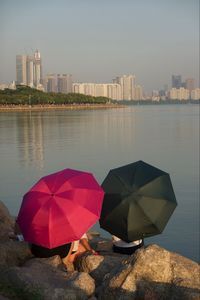 Umbrellas by buildings in city against sky