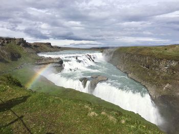 Scenic view of waterfall against sky in iceland 