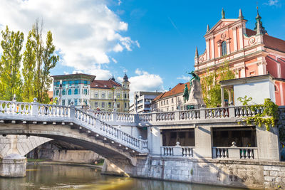 Arch bridge over river against buildings in city
