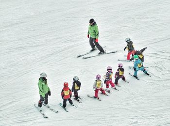 High angle view of ski instructors with students on snow