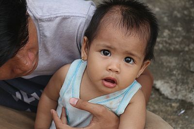 Brother with toddler daughter sitting outdoors