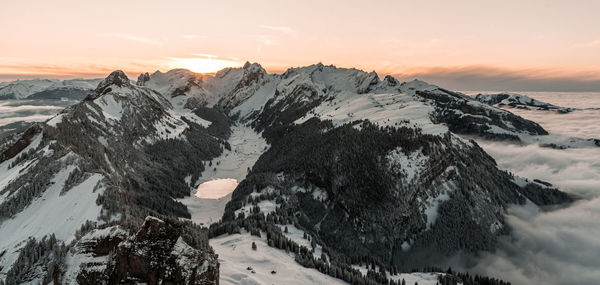 Scenic view of snowcapped mountains against sky during sunset