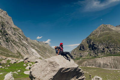 Rear view of man walking on mountain against sky