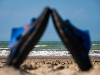 Blurred motion of boat on beach against blue sky