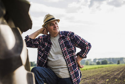 Farmer leaning on tractor at a field