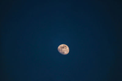 Low angle view of moon against clear blue sky