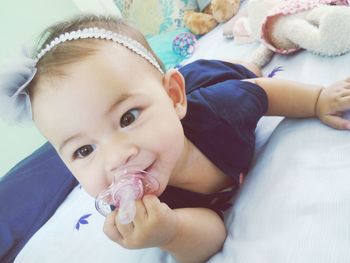 Portrait of cute baby lying on bed