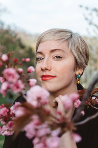 Portrait of young woman by branches in park