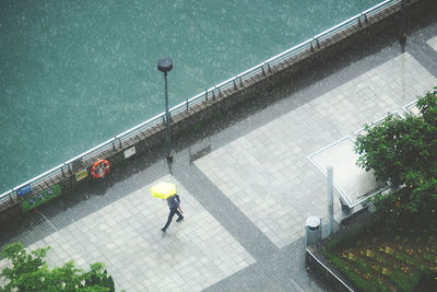 High angle view of man on street in city with an umbrella 