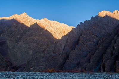 Scenic view of sea and mountains against clear sky