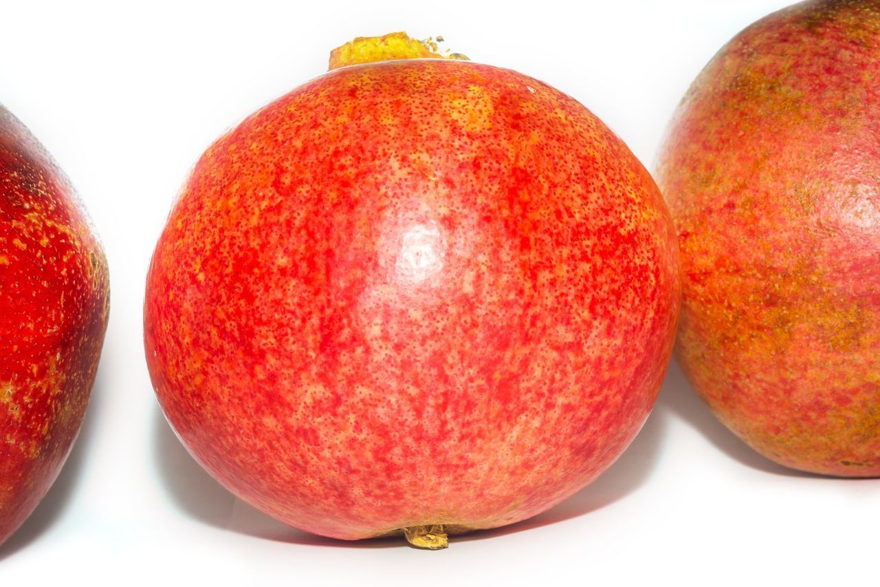 CLOSE-UP OF APPLES ON RED BACKGROUND