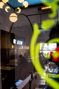 Illuminated lights on street seen through glass window