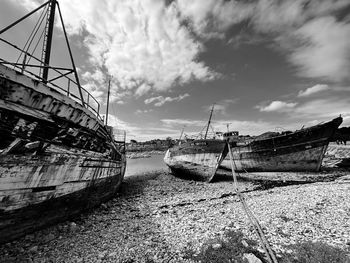 Sailboats moored on beach against sky