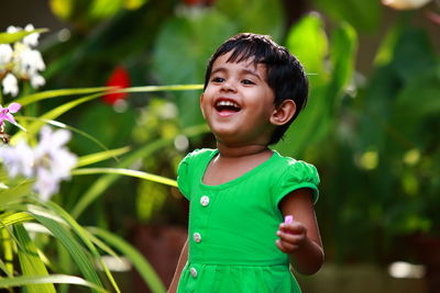 Smiling girl looking away while standing in garden