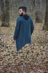 Young man looking away in forest