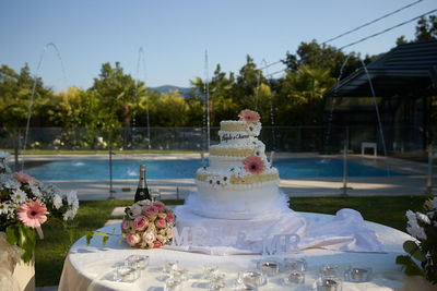 High angle view of cake on table at swimming pool against sky