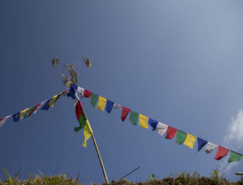 Low angle view of flags hanging against sky