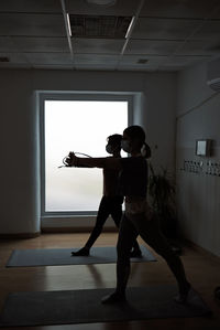 Group of women practicing pilates exercises in class with masks