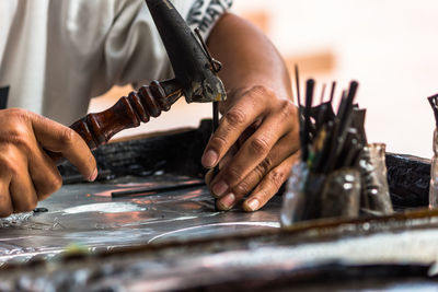 Carpenter hammering nail at workshop