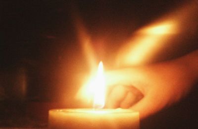 Close-up of lit candle in darkroom