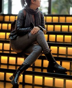 Portrait of young woman sitting on escalator