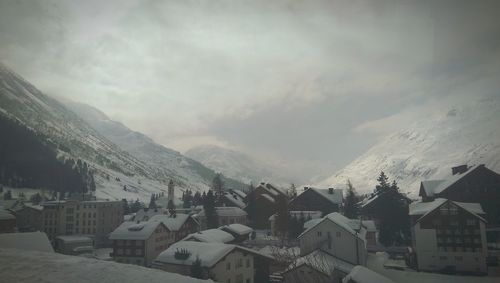 Houses in town against cloudy sky