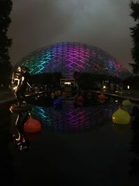 Illuminated swimming pool against sky at night