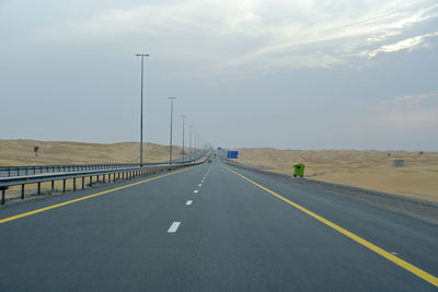 Road by bridge against sky