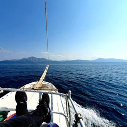 Low section of person sailing on sea against clear sky