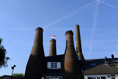 Low angle view of smoke stack against sky