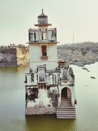 Built structure by sea against clear sky
