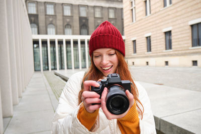 Young woman photographing with camera