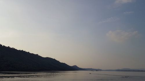 Scenic view of sea and mountains against sky