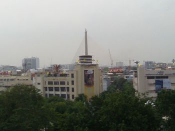 Buildings in city against cloudy sky