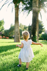 Rear view of woman walking on field