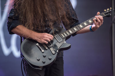 Midsection of woman playing guitar