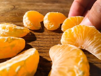 Close up of hand taking a piece of mandarin 
