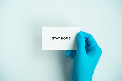 Close-up of hand holding paper against white background