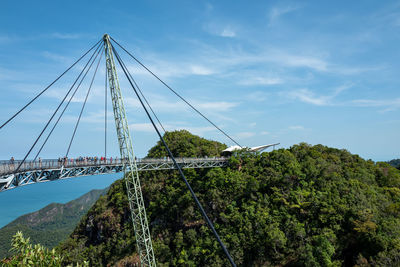 Low angle view of suspension bridge against sky