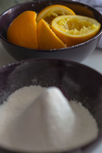 High angle view of flour and oranges in bowls on table