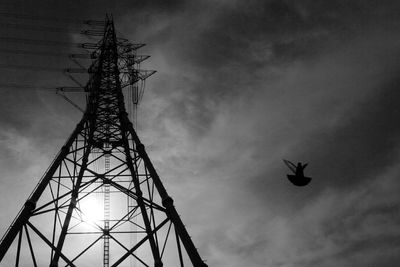 Low angle view of power lines against cloudy sky